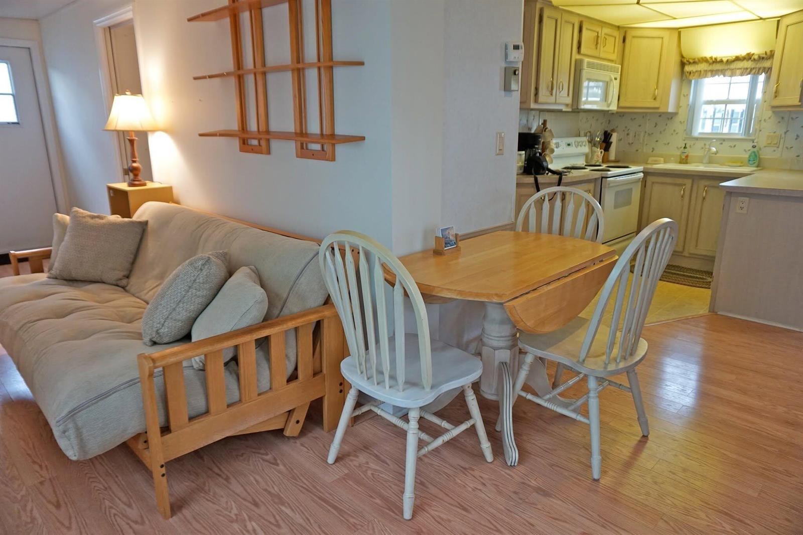 A living area with a futon and dining table next to an open kitchen — 10725 S Ocean Drive # 265, Jensen Beach FL 34957, JENSEN BEACH, FL