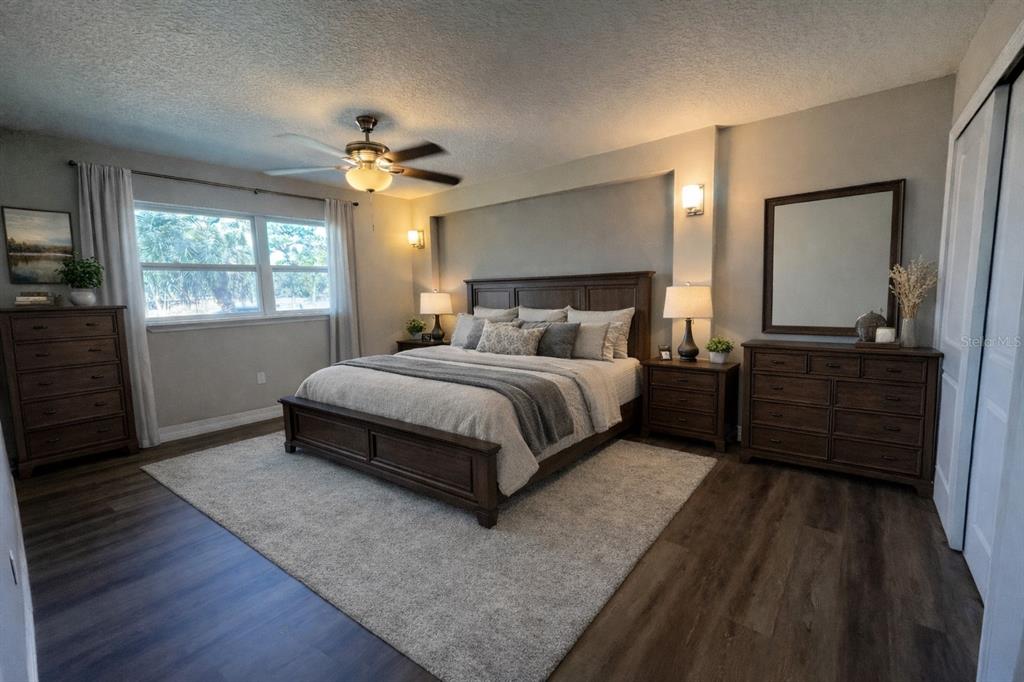 A bedroom features a wooden bed frame, matching dressers, a ceiling fan, and wood-look flooring — 725 SCENIC STREET, LEESBURG, FL