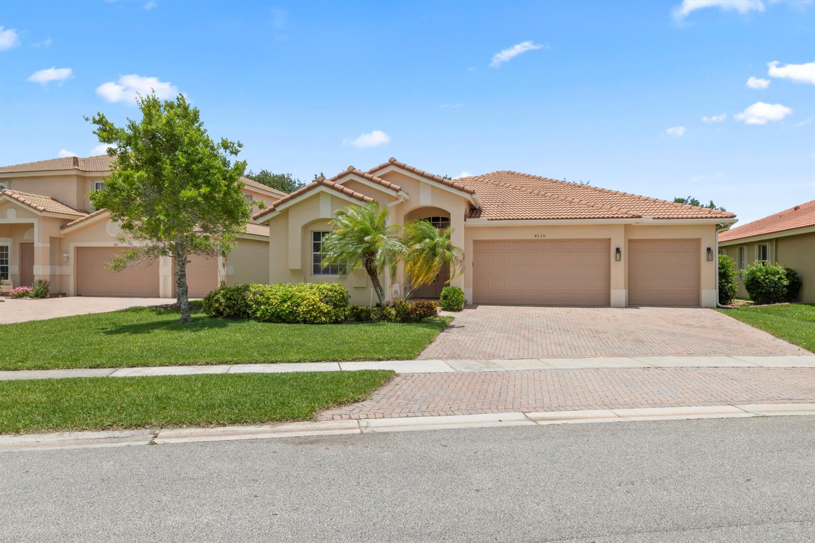 A single-story house with a tile roof, three-car garage, and a paved driveway — 4110 Silverstone Drive, Fort Pierce FL 34947, FORT PIERCE, FL