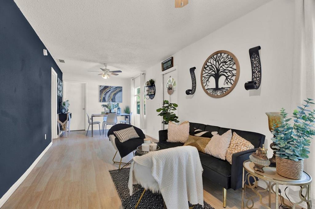 A living room features a dark blue accent wall, a black sofa, and dining area — 2706 E 22ND AVENUE, TAMPA, FL