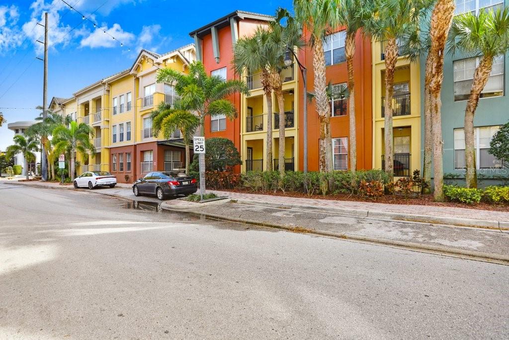 A multi-story apartment building with colorful facades and palm trees along a street — 2440 W HORATIO STREET UNIT 1012, TAMPA, FL