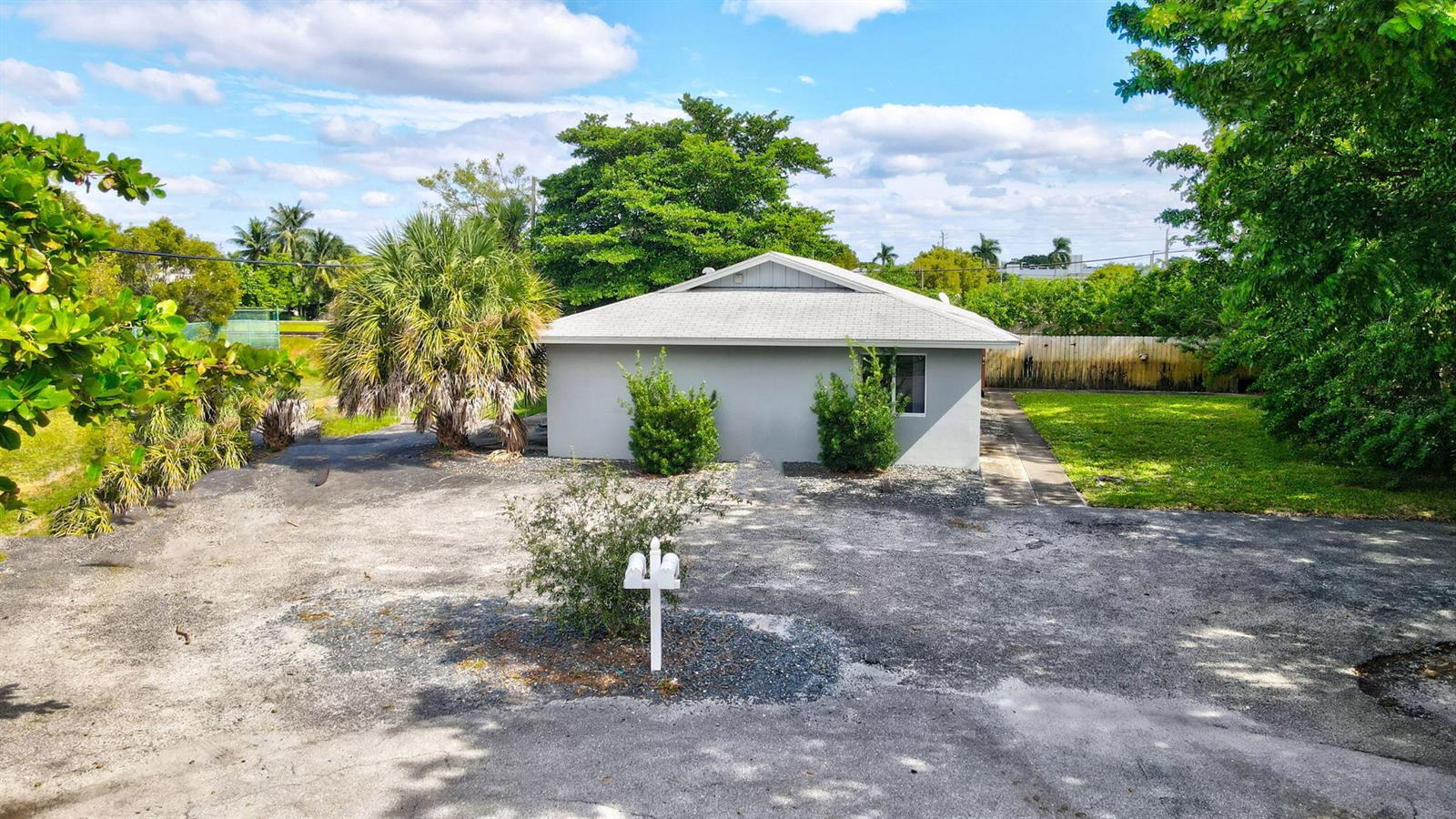 A gray, single-story house sits behind a large, unpaved driveway with a central mailbox — 2227 NE 3rd Avenue # 2, Delray Beach FL 33444, DELRAY BEACH, FL
