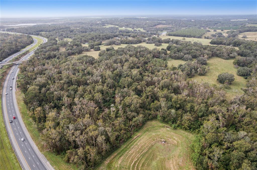 An aerial view shows a highway running alongside a large area of dense forest — 0 CHURCH ROAD, BROOKSVILLE, FL