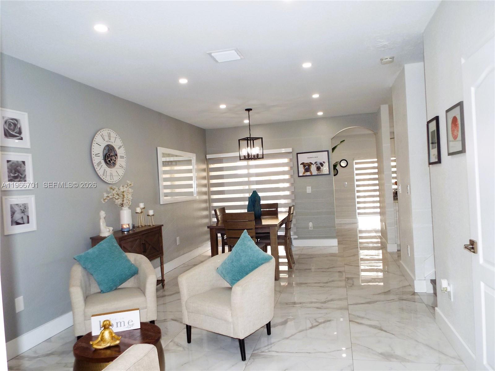 A dining area and sitting space feature light gray walls, marble floors, and modern lighting — 21470 SW 85th Path, Cutler Bay FL 33189, CUTLER BAY, FL