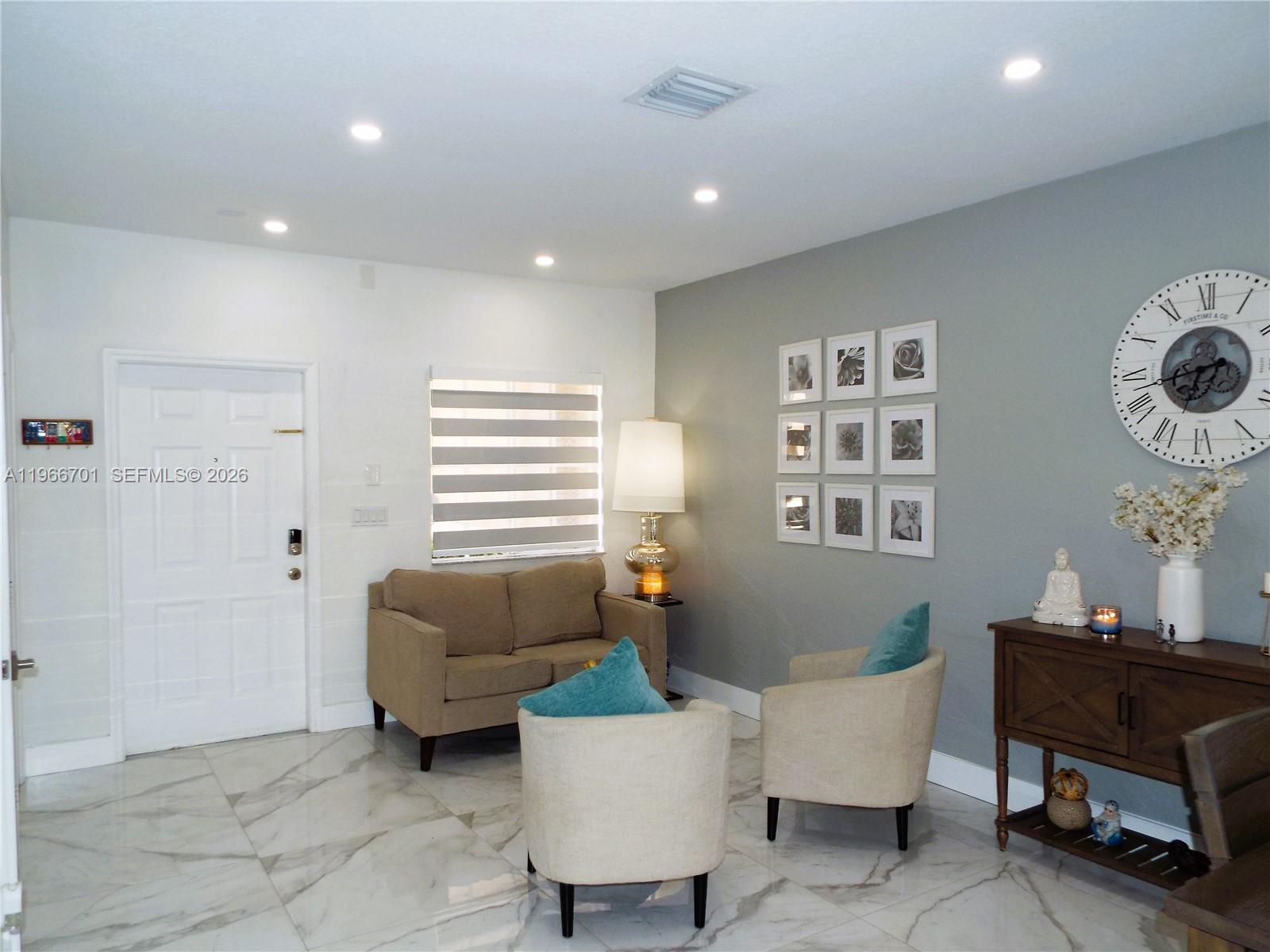 A living room features marble floors, a gray accent wall, and a white front door — 21470 SW 85th Path, Cutler Bay FL 33189, CUTLER BAY, FL