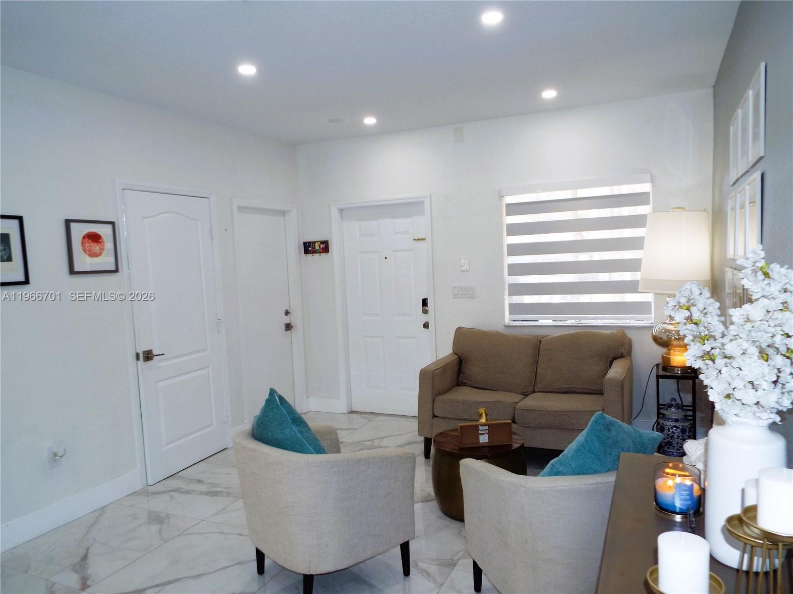 A living room features white marble floors, a beige loveseat, and two accent chairs — 21470 SW 85th Path, Cutler Bay FL 33189, CUTLER BAY, FL