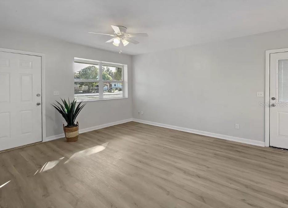 A bright room with light gray walls, wood-look flooring, a ceiling fan, and a potted plant — 4535 38TH COURT, VERO BEACH, FL