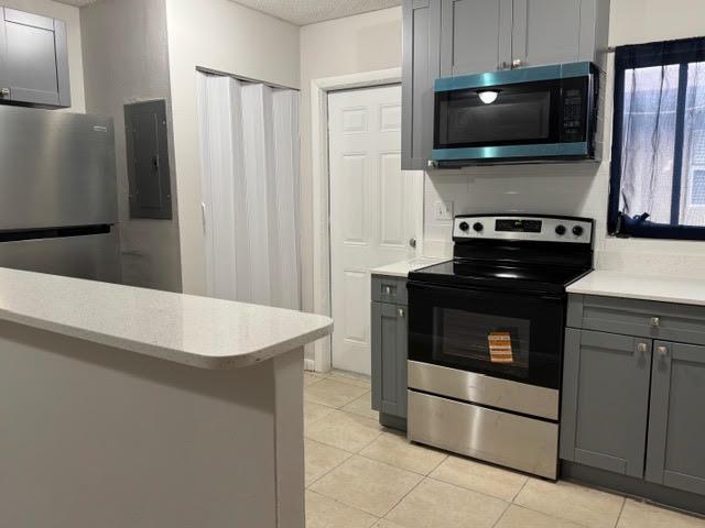 A kitchen features gray cabinets, stainless steel appliances, white countertops, and light tile flooring — 322 SW 2nd Street # 3, Pompano Beach FL 33060, POMPANO BEACH, FL