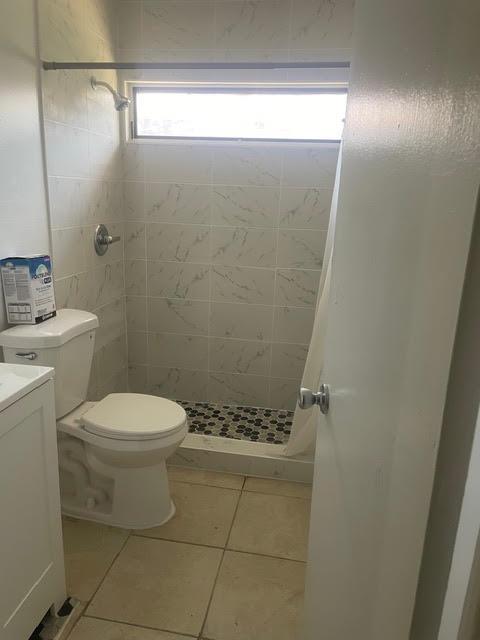 A bathroom featuring a toilet, a vanity, and a tiled shower stall with a window — 322 SW 2nd Street # 3, Pompano Beach FL 33060, POMPANO BEACH, FL