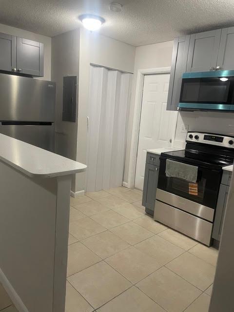 A kitchen with grey cabinets, stainless steel appliances, and light-colored tile flooring — 322 SW 2nd Street # 3, Pompano Beach FL 33060, POMPANO BEACH, FL