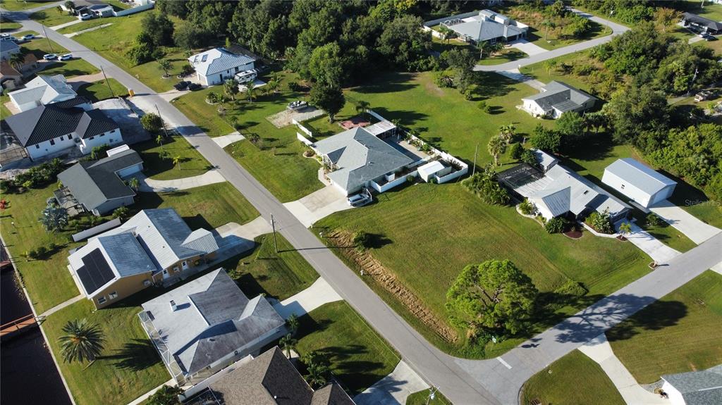 An aerial view shows several suburban houses with driveways and lawns along a paved road — 2297 HARBOUR DRIVE, PUNTA GORDA, FL
