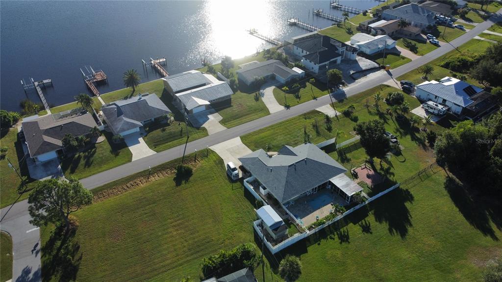 An aerial view shows waterfront houses with docks along a road in a residential neighborhood — 2297 HARBOUR DRIVE, PUNTA GORDA, FL