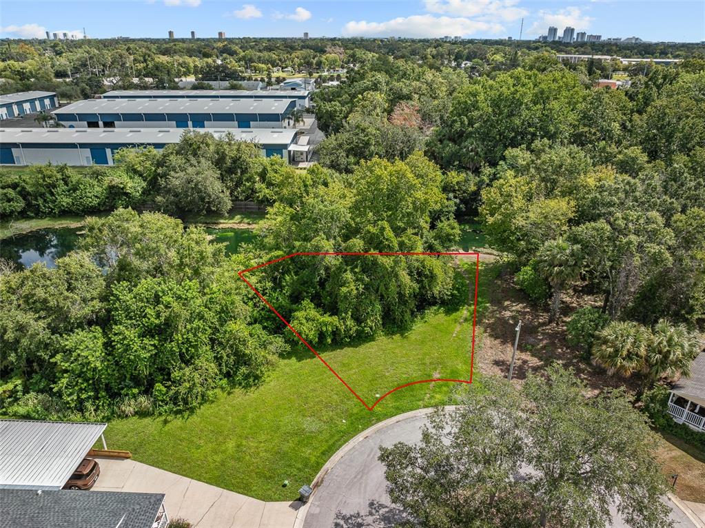 An aerial view shows a vacant, grassy lot outlined in red within a residential cul-de-sac — 1082 YAUPON STREET, DAYTONA BEACH, FL
