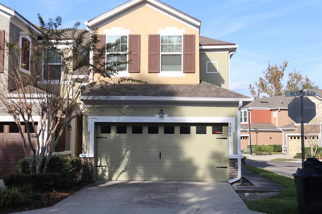 A two-story house with a light green garage, tan upper siding, and brown shutters — 3026 VICTORIA GLEN DRIVE, SANFORD, FL