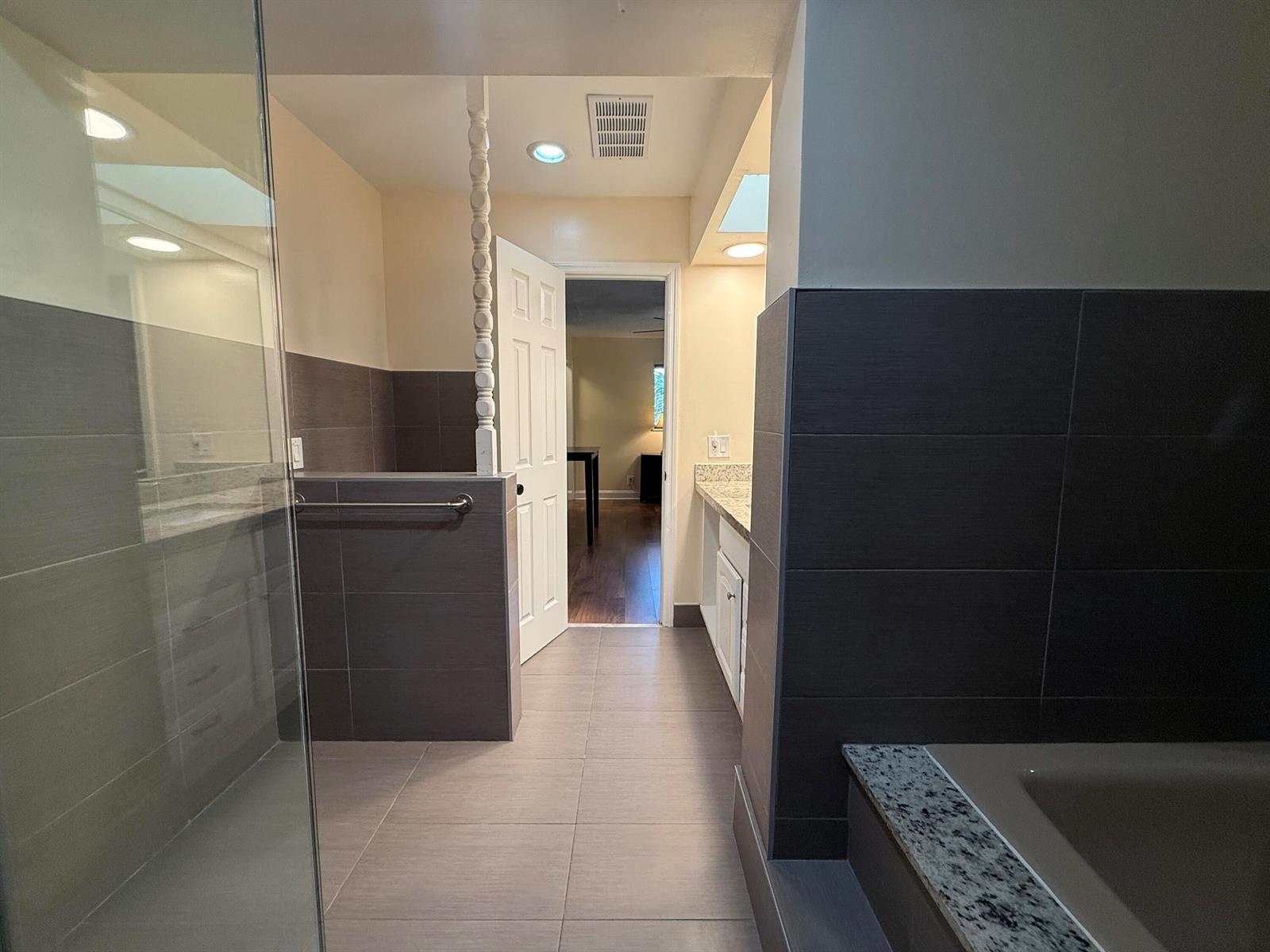 A bathroom features gray tile walls, a glass shower, a soaking tub, and a vanity — 803 NE 2nd Avenue, Delray Beach FL 33444, DELRAY BEACH, FL
