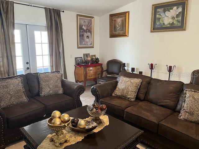 A living room features dark brown leather sofas, a coffee table, and framed wall art — 3723 IMPERIAL DRIVE, WINTER HAVEN, FL