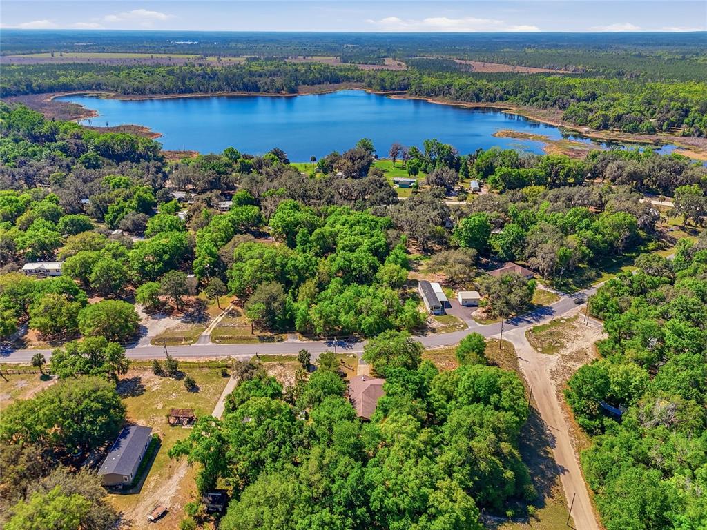 An aerial view shows a lake surrounded by dense trees and several houses — 347 ASHLEY STREET, HAWTHORNE, FL