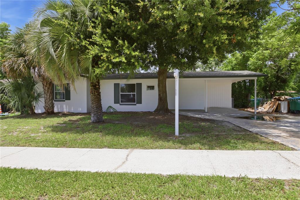 A single-story house with a white exterior, dark shutters, and an attached carport — 2434 CARDENA AVENUE, DELTONA, FL
