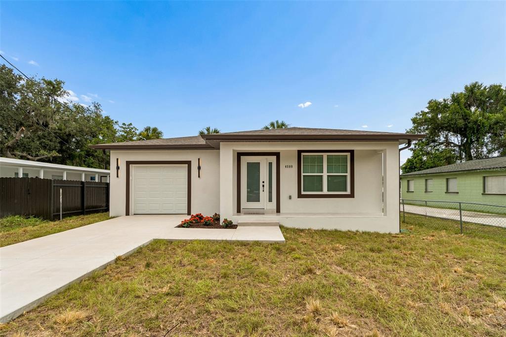 A single-story house with a white stucco exterior, a garage, and a front porch — 4509 N 39TH STREET, TAMPA, FL