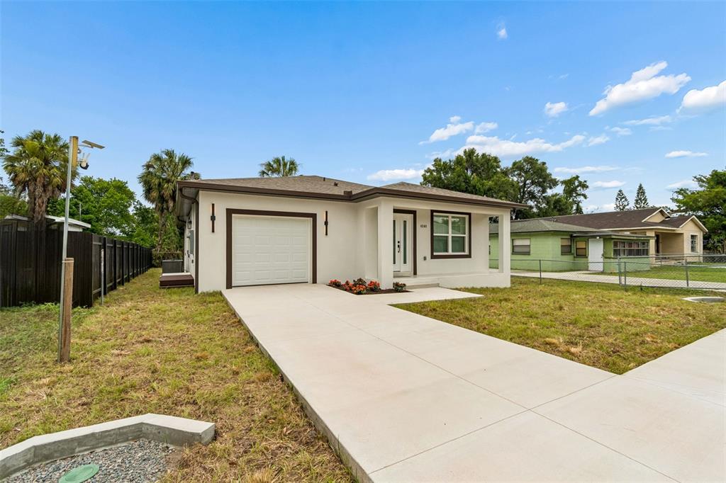 A single-story house with a white exterior, a garage, and a concrete driveway — 4509 N 39TH STREET, TAMPA, FL