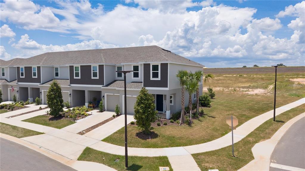 An aerial view of a multi-unit townhouse building with gray siding and attached garages — 7771 WATERSCAPE, GROVELAND, FL