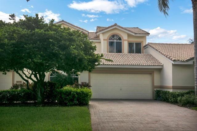 A two-story house with a beige stucco exterior, a tiled roof, and a paved driveway — 676 W Palm Aire Drive, Pompano Beach FL 33069, POMPANO BEACH, FL