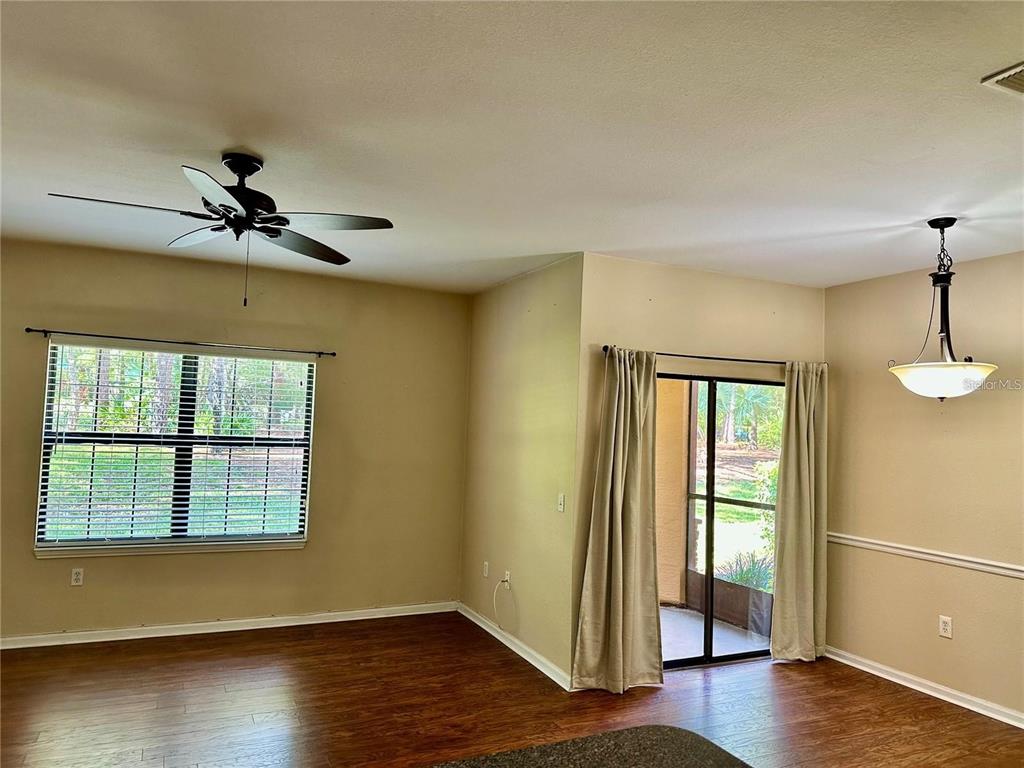 A living and dining area features wood-look flooring, a ceiling fan, and sliding glass doors — 2209 PORTOFINO PLACE UNIT 2516, PALM HARBOR, FL