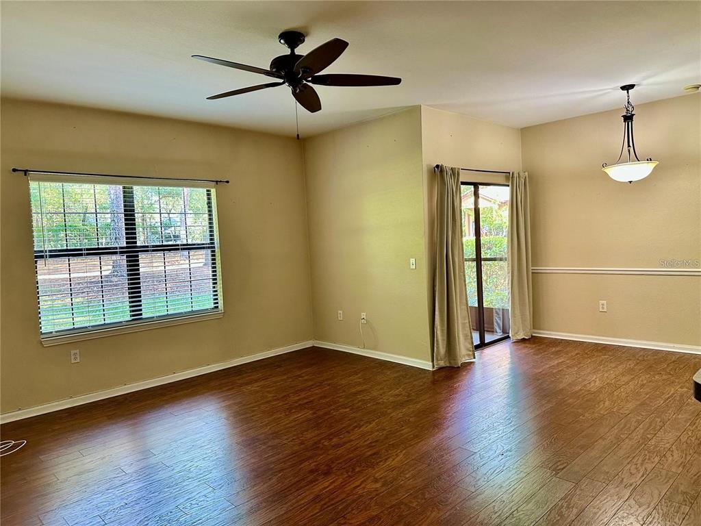 A dining room with wood-look flooring, a ceiling fan, and a sliding glass door — 2209 PORTOFINO PLACE UNIT 2516, PALM HARBOR, FL