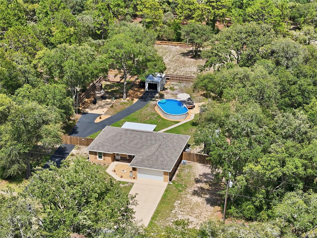 An aerial view shows a single-story house with a driveway, backyard pool, and detached garage — 4171 SW SHASTA COURT, DUNNELLON, FL