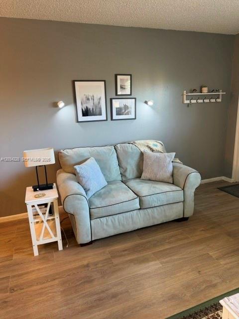 A light blue loveseat sits against a gray wall with framed art and wall sconces — SUNRISE, FL