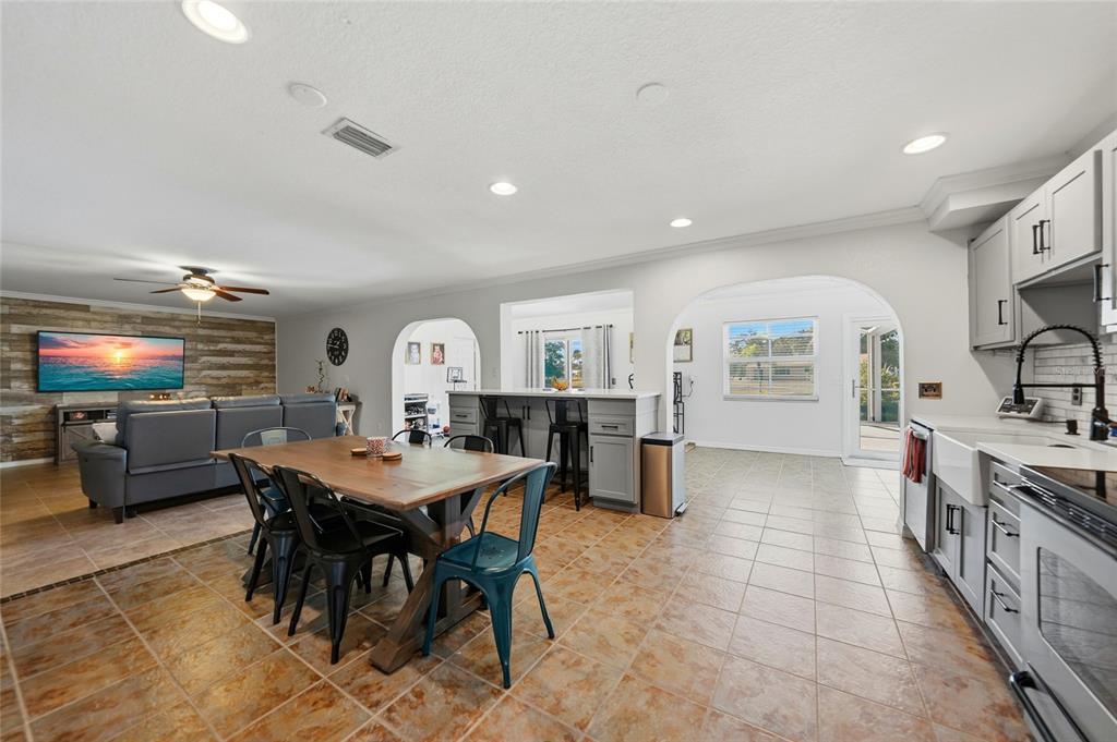 A swimming pool with a stone border sits inside a screened lanai overlooking a lake — 4053 PINSTAR TERRACE, NORTH PORT, FL