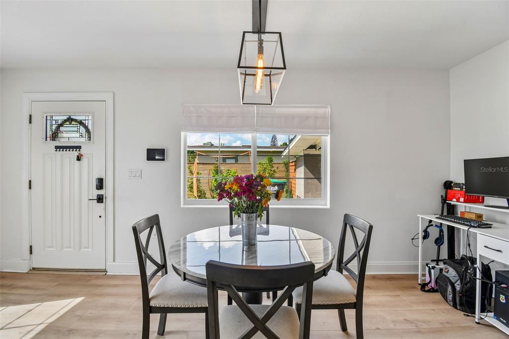A dining area features a round glass table, three chairs, and a modern pendant light — 259 ORANGE TERRACE DRIVE, WINTER PARK, FL