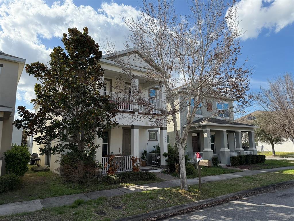Two adjacent two-story houses with front porches and balconies sit along a sidewalk — 8272 BRYCE CANYON AVENUE, WINDERMERE, FL
