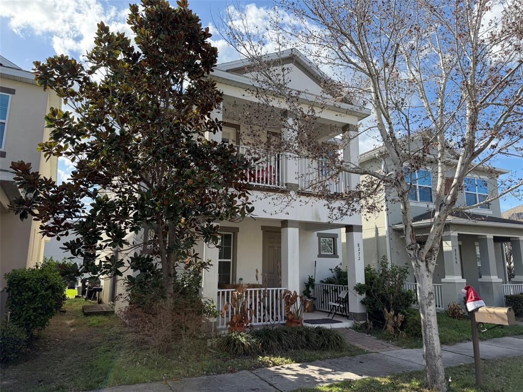 A two-story house with a white exterior, a front porch, and a second-floor balcony — 8272 BRYCE CANYON AVENUE, WINDERMERE, FL
