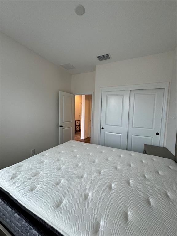 A bedroom features a mattress, white walls, a closet with sliding doors, and an open doorway — 3339 NW 52ND AVENUE ROAD, OCALA, FL