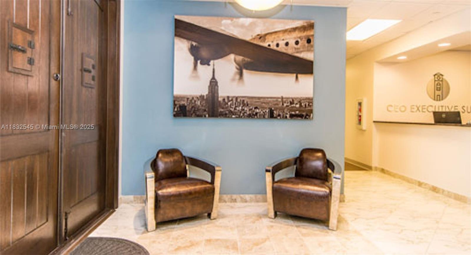 An office lobby features two brown leather chairs, a large wall print, and wooden doors — 1555 Bonaventure Blvd # 2019, Weston FL 33326, WESTON, FL