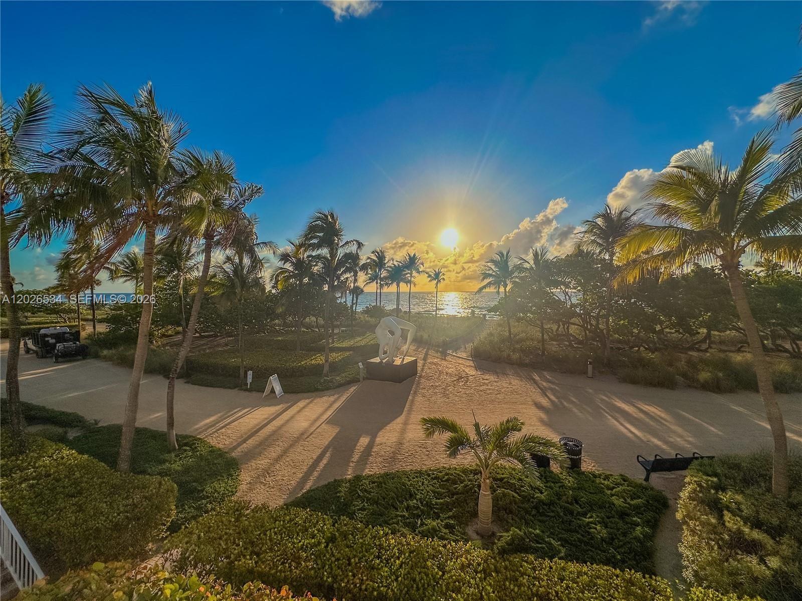 A sandy path leads through palm trees toward a beach with a central sculpture — 9801 Collins Ave # 6P, Bal Harbour FL 33154, BAL HARBOUR, FL