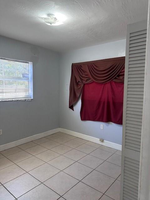 A room with light gray walls, tiled floors, a window with blinds, and draped curtains — 3723 NW 23rd Ave # 2, Miami FL 33142, MIAMI, FL