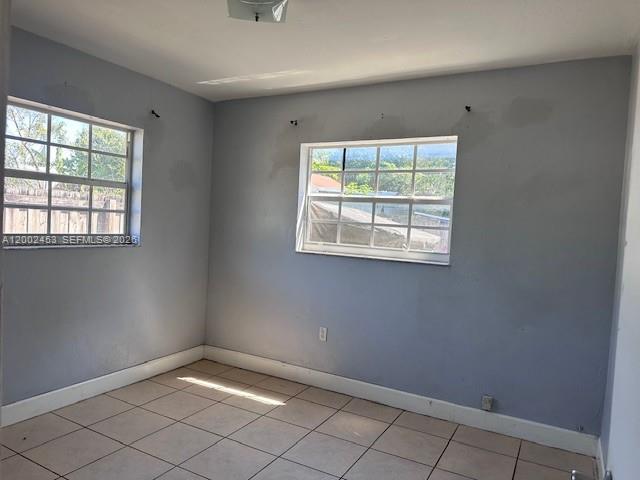 An empty room features light gray walls, tiled flooring, and two windows with white frames — 3723 NW 23rd Ave # 2, Miami FL 33142, MIAMI, FL