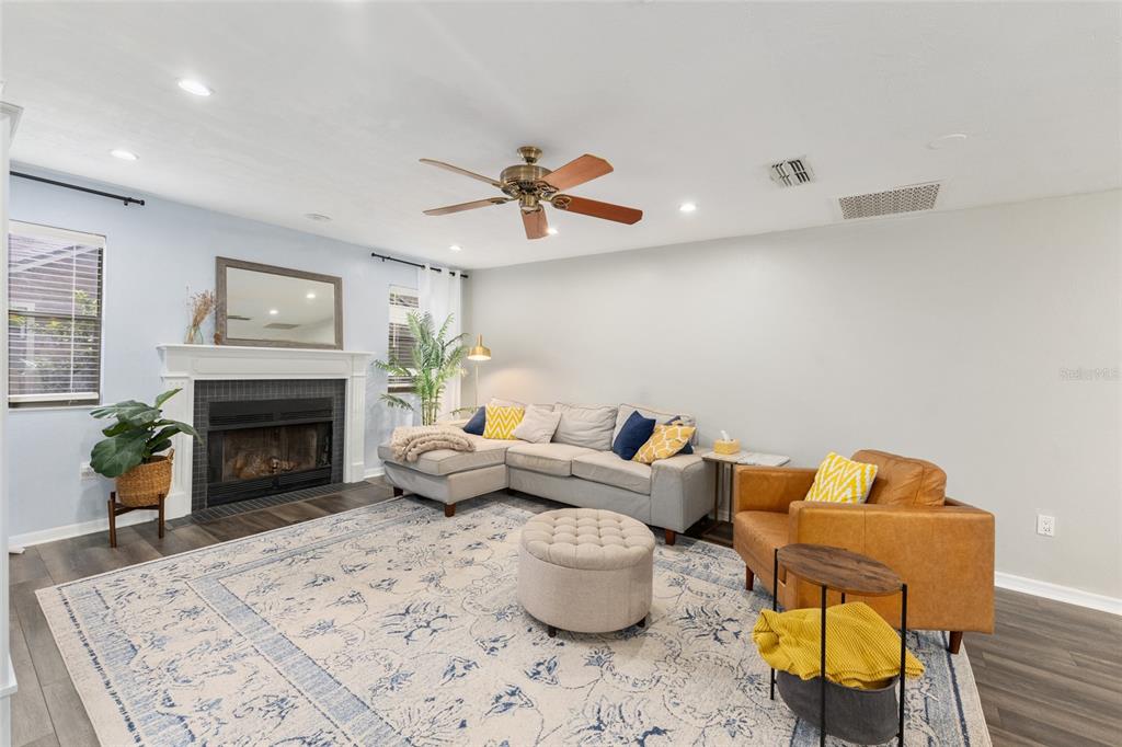 A living room features a fireplace, a sectional sofa, a leather armchair, and a rug — 8005 SW 47TH COURT, GAINESVILLE, FL