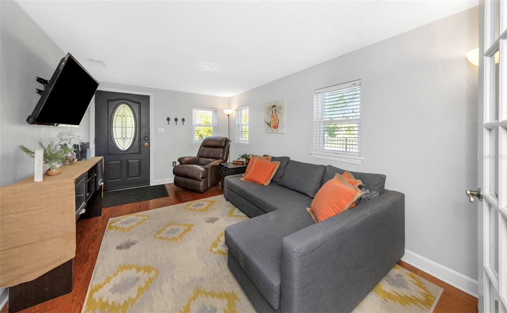 A living room features a gray sectional sofa, a brown recliner, and a dark front door — 414 TAMPA ROAD, PALM HARBOR, FL