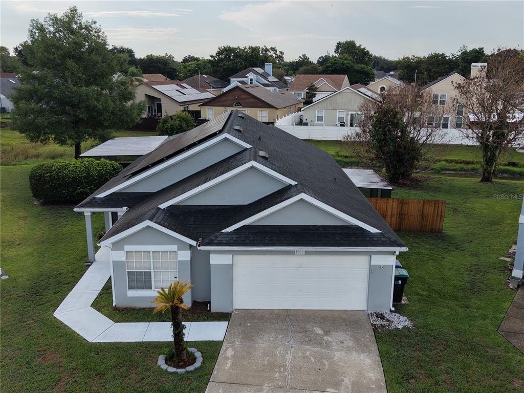 An aerial view of a gray single-story house with a black roof and solar panels — 4702 FORT BRAVO COURT, ORLANDO, FL