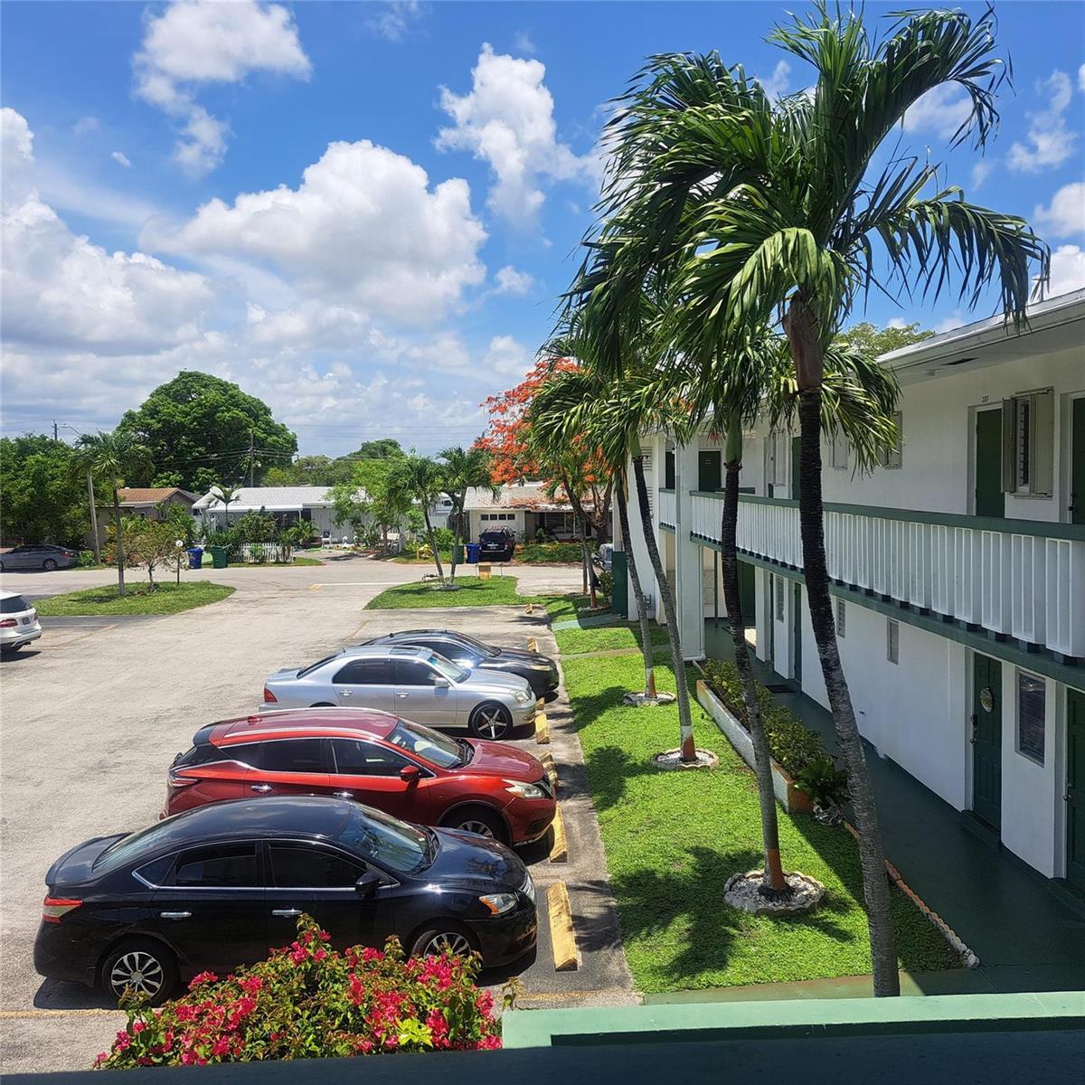 An elevated view of a parking lot next to a two-story apartment building with palms — 6730 Arbor Drive # 210, Miramar FL 33023, MIRAMAR, FL