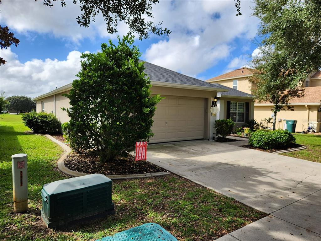 A single-story house with a beige exterior, a two-car garage, and a landscaped front yard — 4740 SW 41ST STREET, OCALA, FL
