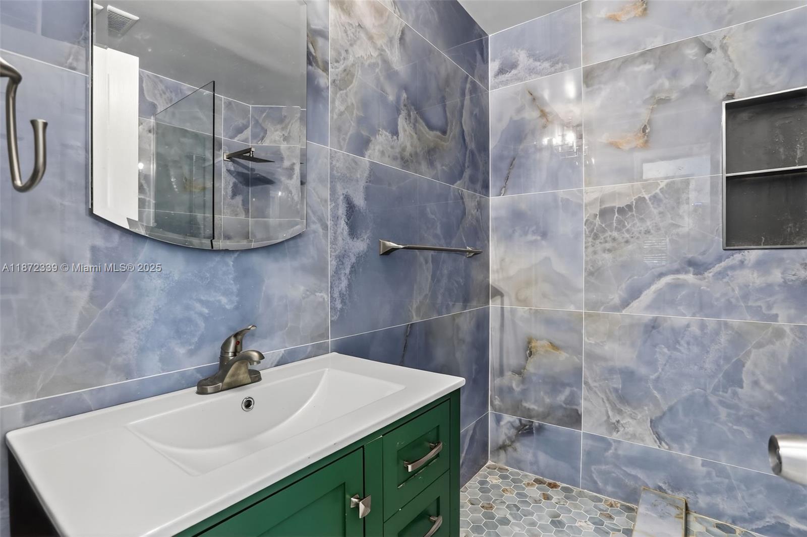 A bathroom features a green vanity, a white sink, and blue marble-patterned wall tiles — 2681 NW 63rd Ave, Margate FL 33063, MARGATE, FL