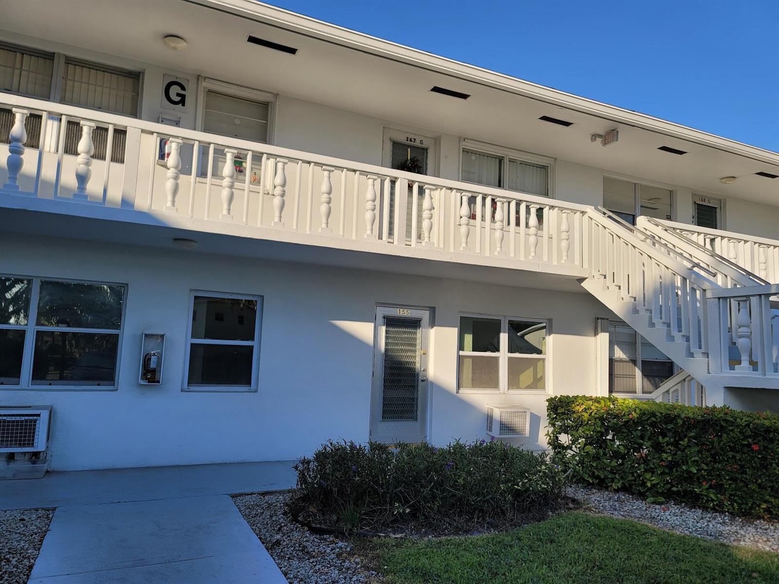 A two-story white apartment building features an exterior staircase and a second-floor balcony — 155 Coventry, West Palm Beach FL 33417, WEST PALM BEACH, FL