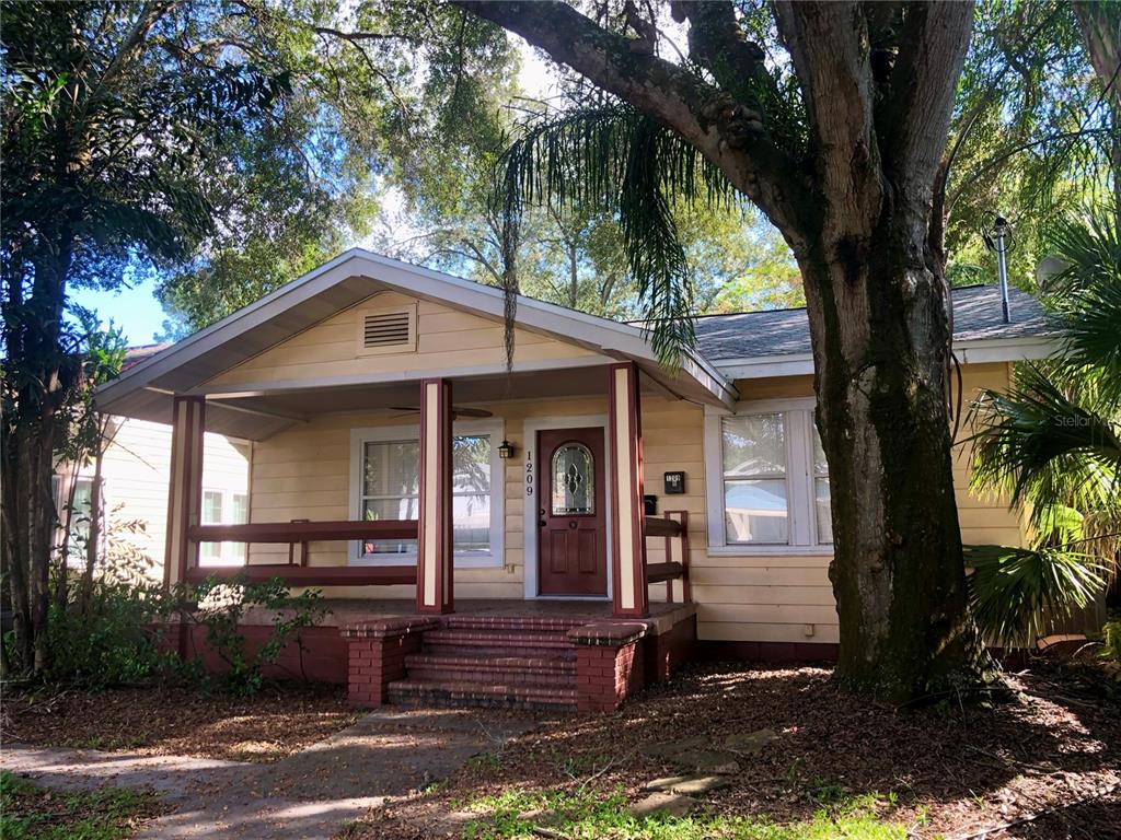 A single-story house with yellow siding, a covered front porch, and a brick foundation — 1209 E COMANCHE AVENUE, TAMPA, FL