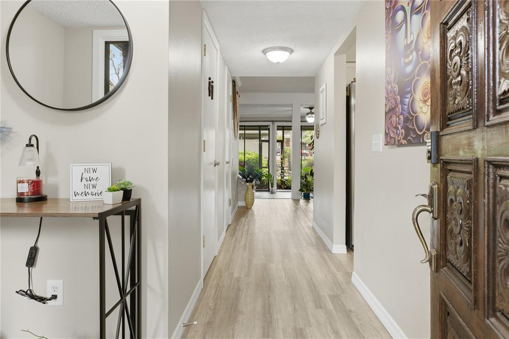 A hallway with light wood-look flooring leads to a screened-in porch with a glass door — 654 LAKE VILLAS DRIVE UNIT 654, ALTAMONTE SPRINGS, FL