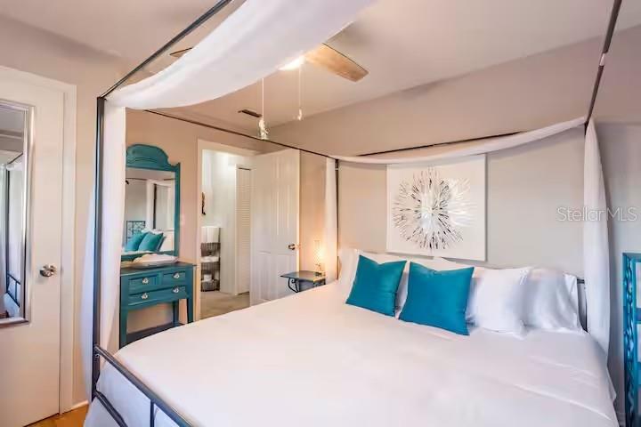 A bedroom features a four-poster bed with white drapes and teal accent pillows — 2035 28TH AVENUE N UNIT 1/2, ST PETERSBURG, FL