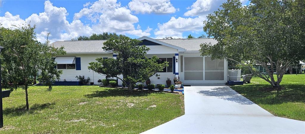 A single-story house with white siding, a screened-in porch, and a concrete driveway — 10957 SW 79TH TERRACE, OCALA, FL